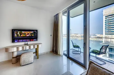 a living room with a tv and a large window at Phenomenal 2BD with the beach in Dubai