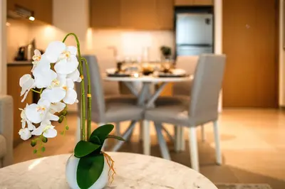 a table with a vase with white flowers on it at Nice 1BD Apartment in Surf at Creek Beach in Dubai