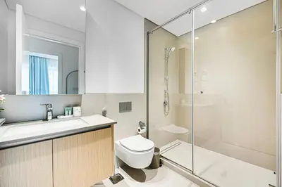 a bathroom with a shower and a toilet and a sink at Nice 1BD Apartment in Surf at Creek Beach in Dubai