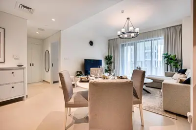 a dining room and living room with a table and chairs at Nice 1BD Apartment in Surf at Creek Beach in Dubai