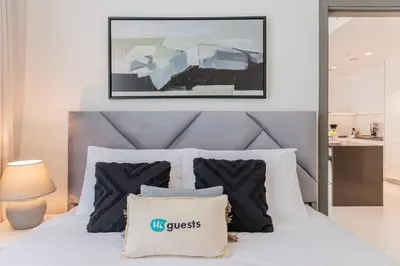 a bedroom with a white bed with a blue headboard at HiGuests - Step Into Heaven In This Lakeside Apartment in Dubai