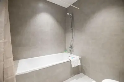 a bathroom with a bath tub with a towel at HiGuests - Step Into Heaven In This Lakeside Apartment in Dubai