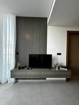 a living room with a flat screen tv on a table at Prime 1BR in Sobha Hartland, Burj Khalifa view in Dubai