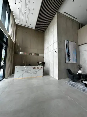a large room with a lobby with a table and chairs at Prime 1BR in Sobha Hartland, Burj Khalifa view in Dubai