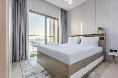 a bedroom with a large bed and a large window at STAY BY LATINEM Luxury 1BR Holiday Home CVR A413 near Burj Khalifa in Dubai