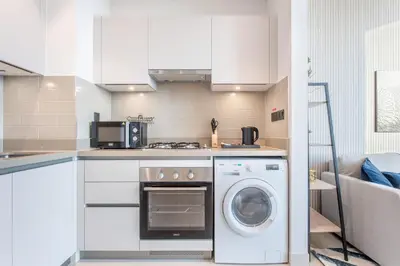 a kitchen with a washing machine and a microwave at STAY BY LATINEM Luxury 1BR Holiday Home CVR A413 near Burj Khalifa in Dubai