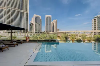 a swimming pool with a city skyline in the background at GuestReady - Lux living with an infinity pool in Dubai