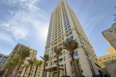 a tall building with palm trees in front of it at GuestReady - Lux living with an infinity pool in Dubai