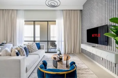 a living room with a couch and a tv at GuestReady - Lux living with an infinity pool in Dubai