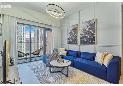 a living room with a blue couch and a table at bnbme - Chic 1BR Apt w Balcony Pool Gym Access Steps to Burj Khalifa & Dubai Mall in Dubai