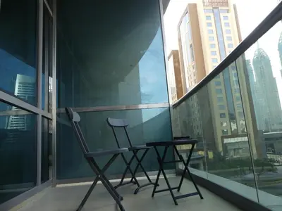a chair sitting on a balcony in front of a window at Studio Apartment - Cozy, Very Accessible and so near to Train Station in Dubai
