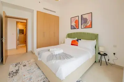 a bedroom with a large white bed with a green headboard at Lux Golf Views 3 BR in Emirates Hills in Dubai