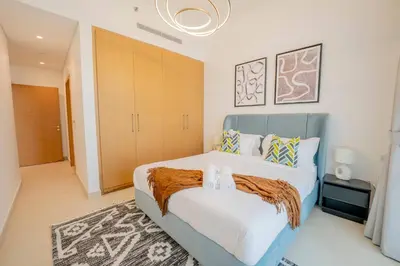 a bedroom with a large bed with a blue headboard at Lux Golf Views 3 BR in Emirates Hills in Dubai