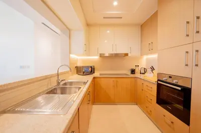 a large kitchen with a sink and a stove at Lux Golf Views 3 BR in Emirates Hills in Dubai