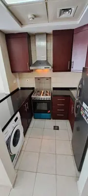 a kitchen with a stove and a washing machine at DRUVYA HOLIDAY HOMES, Bld DG083, Street No,3 Discovery Gardens, Close to The Gardens Metro 6 minutes walkable in Dubai