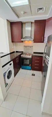 a kitchen with a stove and a washing machine at DRUVYA HOLIDAY HOMES, Bld DG083, Street No,3 Discovery Gardens, Close to The Gardens Metro 6 minutes walkable in Dubai