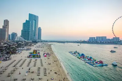 a beach with a bunch of people in the water at Luxury 2 Bedroom Apartment in Dubai Marina & JBR Beach in Dubai