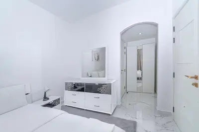 a white bedroom with a bed and a mirror at Luxury 2 Bedroom Apartment in Dubai Marina & JBR Beach in Dubai
