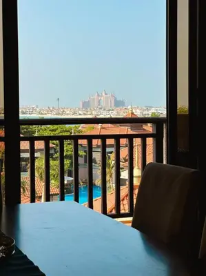 a blue table and chairs on a balcony with a view at Family friendly apt at Palm in Dubai