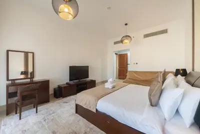 a bedroom with a large bed and a television at Modern 1BR in Vibrant Fairmont North Residence - 90AB6 in Dubai