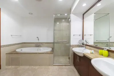 a bathroom with two sinks and a tub and a shower at Modern 1BR in Vibrant Fairmont North Residence - 90AB6 in Dubai