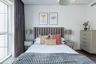 a bedroom with a large bed with pink pillows at GuestReady - Exquisite residence in Dubai Marina in Dubai