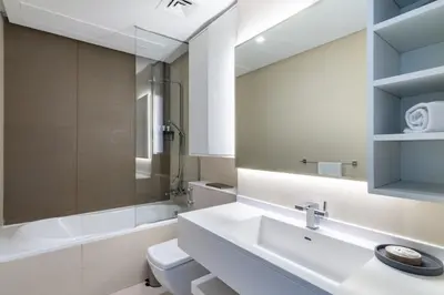 a bathroom with a sink and a toilet and a mirror at GuestReady - Exquisite residence in Dubai Marina in Dubai