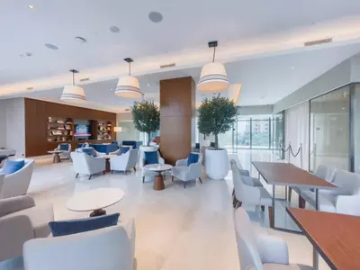 a lobby with white chairs and tables at Stunning Full Burj Khalifa View - The Address 2BR Luxury in Dubai