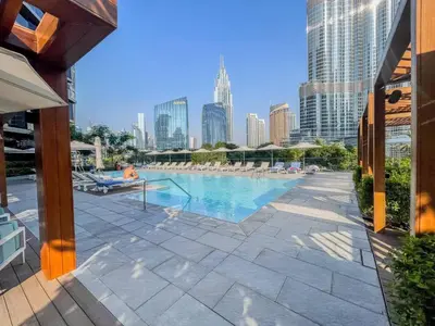 a swimming pool with a city skyline in the background at Stunning Full Burj Khalifa View - The Address 2BR Luxury in Dubai