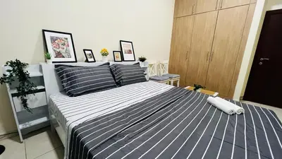 a bedroom with a large bed with blue and white stripes at Beautiful Bedroom in Al Barsha Near Mashreq Metro in Dubai