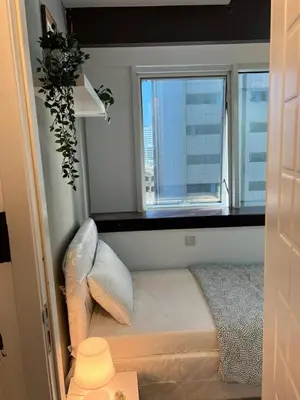a small bedroom with a window and a bed at Dreamy Partition Room in Barsha1 in Dubai