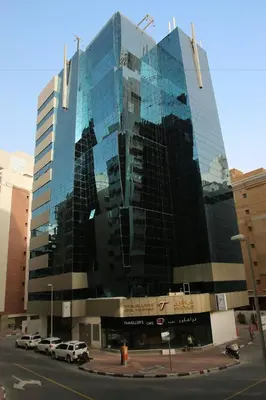 a large glass building with cars parked in front of it at Epic Partition Room in Barsha Near Metro in Dubai