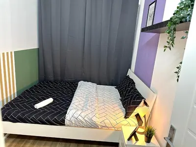 a small bed with a black and white comforter at Beautiful Double Partition Room in Tecom Near ICM Metro in Dubai