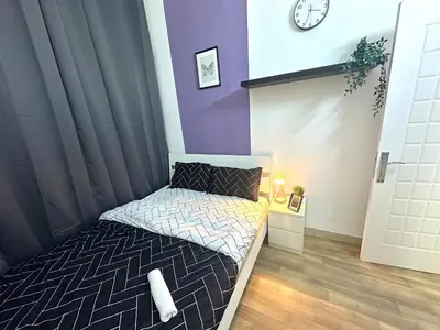 a small bedroom with a bed and a clock on the wall at Beautiful Double Partition Room in Tecom Near ICM Metro in Dubai