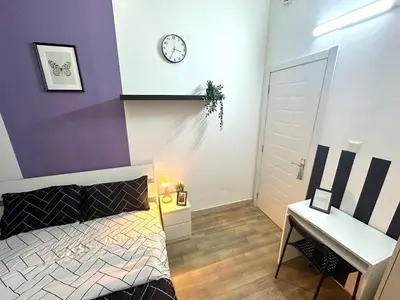 a bedroom with a bed and a clock on the wall at Beautiful Double Partition Room in Tecom Near ICM Metro in Dubai