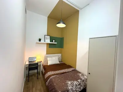 a small bedroom with a bed and a desk at Budget Double Partition Room in Barsha Heights Near Metro in Dubai
