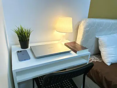 a table with a laptop and a lamp on it at Budget Double Partition Room in Barsha Heights Near Metro in Dubai