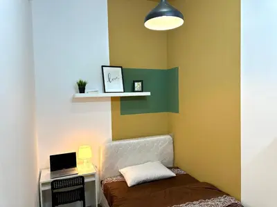 a room with a bed and a desk with a laptop at Budget Double Partition Room in Barsha Heights Near Metro in Dubai