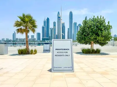 a sign in a park with a view of a city at Seaside Serenity Perfect Beachfront Holiday Haven in Dubai