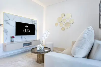 a living room with a white couch and a tv at STAY BY LATINEM Luxury 1BR Holiday Home CVR B2704 near Burj Khalifa in Dubai
