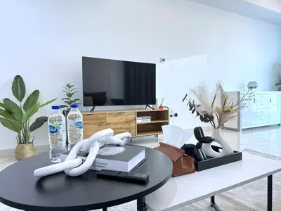 a living room with a coffee table with a tv at Deluxe Apartment With Panoramic View Near Metro in Dubai