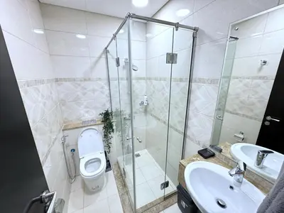 a bathroom with a toilet and a sink and a shower at Deluxe Apartment With Panoramic View Near Metro in Dubai
