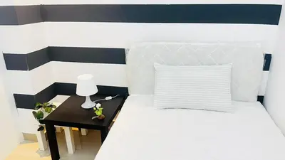 a bedroom with a bed and a table with a lamp at Fashion Partition Room Near Mall of The Emirates in Dubai