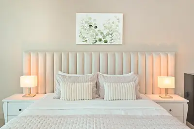 a bedroom with a white bed with two lamps at Difc 1 Bd apartment in Park Tower in Dubai