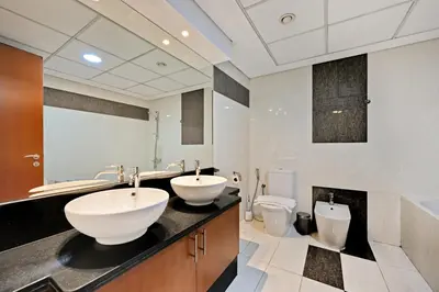 a bathroom with two sinks and a toilet at Difc 1 Bd apartment in Park Tower in Dubai