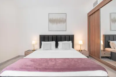 a bedroom with a large bed and two lamps at Lux BnB Princess Tower Palm Ocean Views in Dubai