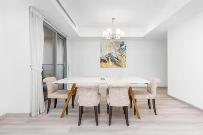 a dining room with a white table and chairs at Lux BnB Princess Tower Palm Ocean Views in Dubai