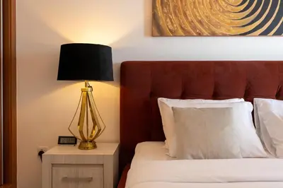 a bedroom with a bed with a lamp on a night stand at Lux BnB Princess Tower Palm Ocean Views in Dubai