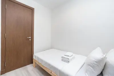 a bedroom with a bed and a wooden cabinet at Lux BnB Princess Tower Palm Ocean Views in Dubai