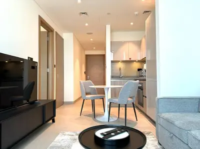 a living room with a couch and a table and chairs at Stylish brand new 1 bedroom in Dubai